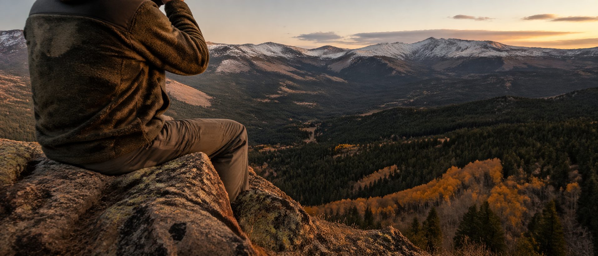 Lone hunter from behind glassing through binoculars over Montana drainage, HuntPremium prefooter